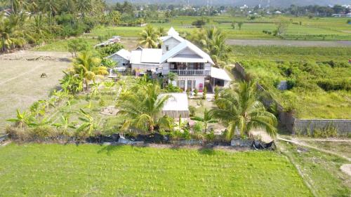 une vue aérienne sur une maison dans un champ dans l'établissement The Daun Puntik HomeStay, à Pawenang