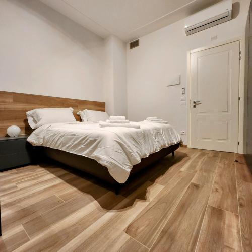 a bedroom with a large bed and a wooden floor at b&b marconi 49 in Bologna