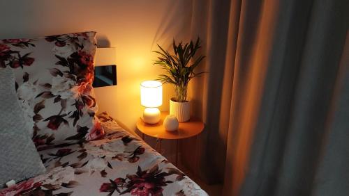 a bedroom with a bed and a lamp on a table at Apartment Mokotów blisko lotniska Chopina in Warsaw