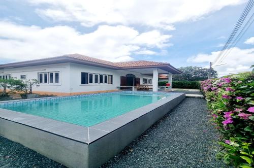 a swimming pool in front of a house at Mae Rampung Beach House Pool Villa in Rayong