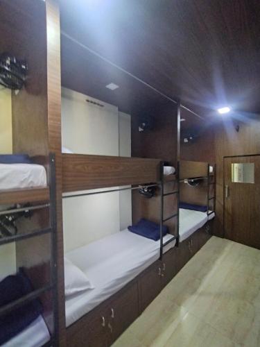 a room with three bunk beds on a boat at DC Dormitory Asalpha Metro in Mumbai