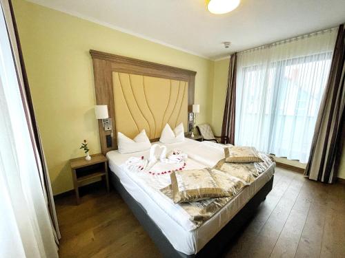 sypialnia z dużym łóżkiem i dużym oknem w obiekcie Naam Hotel & Apartments Frankfurt City-Messe Airport w Frankfurcie nad Menem