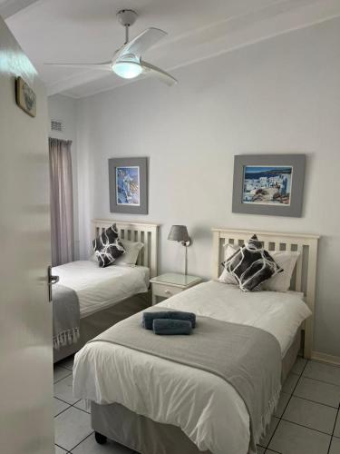 a bedroom with two beds and a ceiling fan at Villa Del Sol Unit 8 in Margate
