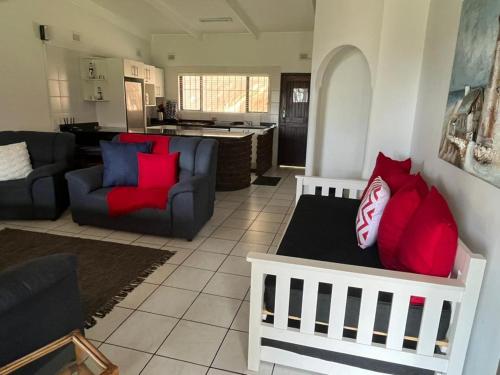 a living room with red pillows on a couch at Villa Del Sol Unit 8 in Margate