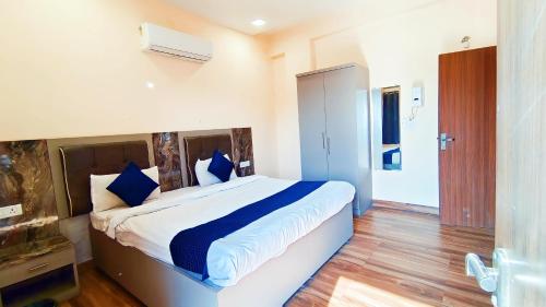 a bedroom with a large bed with blue pillows at HOTEL THE VILLA in Bhopal