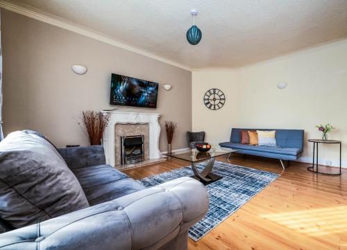 a living room with a couch and a fireplace at Spacious Apartment - Parking - Sleeps 5 in Great Coates