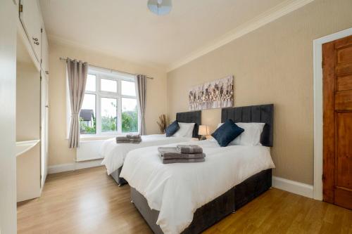 a bedroom with two beds and a window at Spacious flat in central location with parking in Great Coates