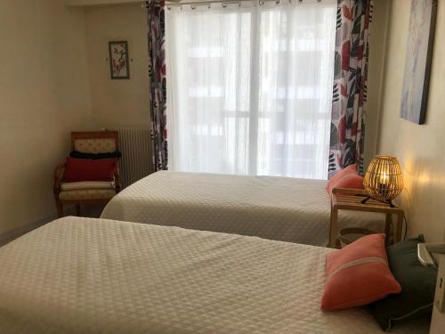 een slaapkamer met twee bedden en een raam bij Appartement Vue Mer 75 m2 in Saint-Raphaël