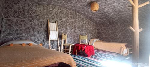 a bedroom with a bed and chairs in a room at Serdrar Camp in Timganine