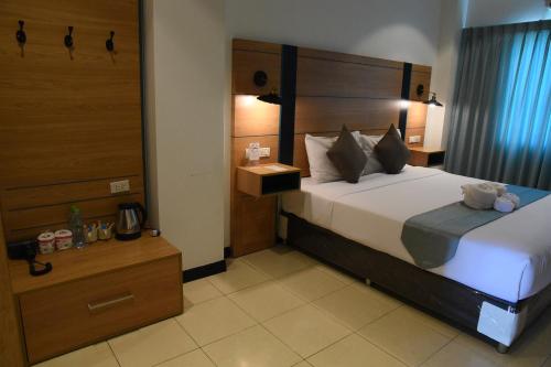 a bedroom with a large bed with a wooden headboard at The Base Inn Pattaya in Pattaya Central