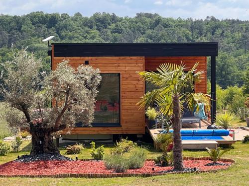 a small cabin in the middle of a field with trees at LOVE AND BULLES in Le Fleix