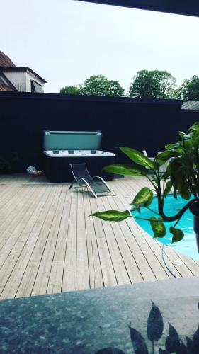 a patio with a bench and a table and a plant at Split in Veberöd