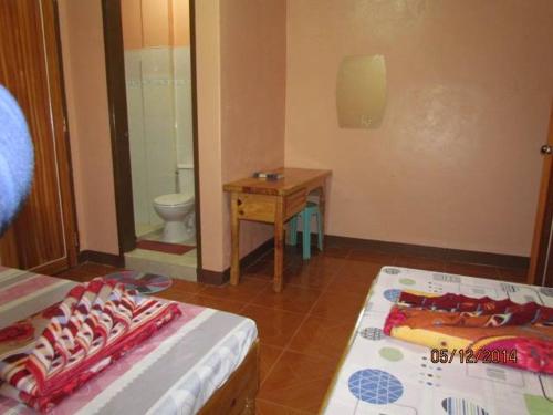 a room with a bed and a bathroom with a toilet at TRIPLE JS INN-SAGADA in Sagada