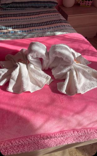 a pink blanket with a bow on a bed at APARTMENT Aurora & Nicole IDEAL per bike 1 free parkings large e wi-fi free e x family mtb climbing con terazza vista mare in Pietra Ligure