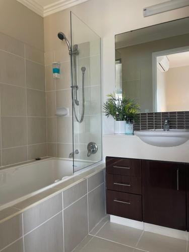 a bathroom with a tub and a sink and a shower at Sea / lake townhouse in Rockingham