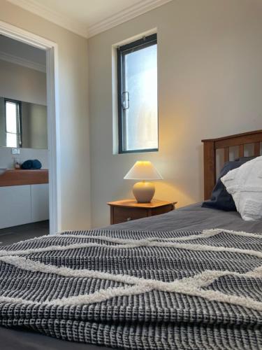 Un dormitorio con una cama grande y una ventana en Sea / lake townhouse, en Rockingham
