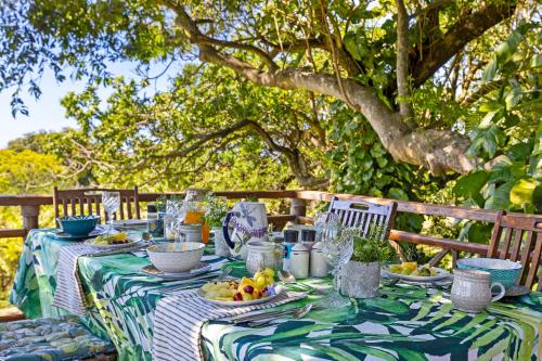 Seaforth Country House في باليتو: طاولة عليها قماش الطاولة الخضراء والبيضاء مع الفاكهة