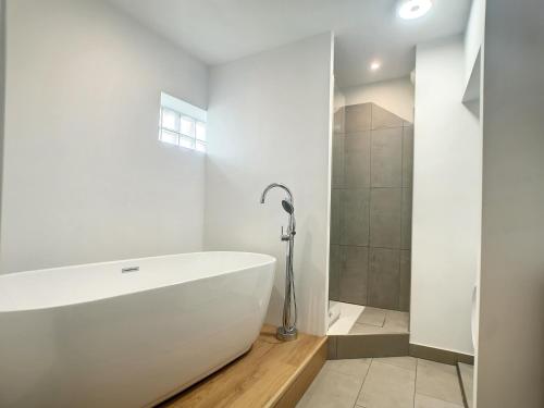 佩里格的住宿－Appartement la cité，白色的浴室设有浴缸和淋浴。
