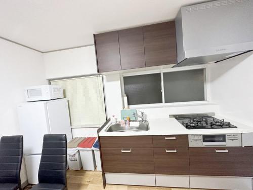 a kitchen with a sink and a stove at 無料駐車場有車種制限有!USjまで近く!空庭温泉徒歩圏海遊館!最大7名 in Osaka