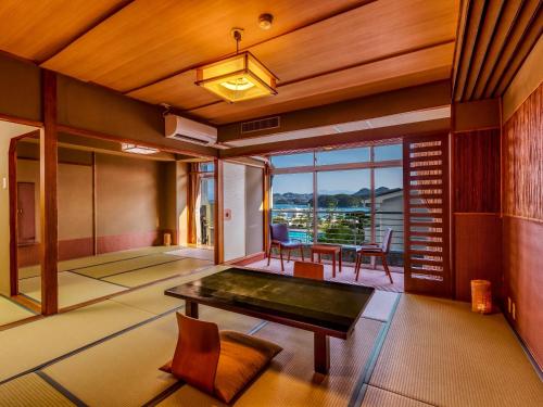 Habitación con mesa de ping pong y balcón. en Yukai Resort Premium Shirahama Saichoraku, en Shirahama