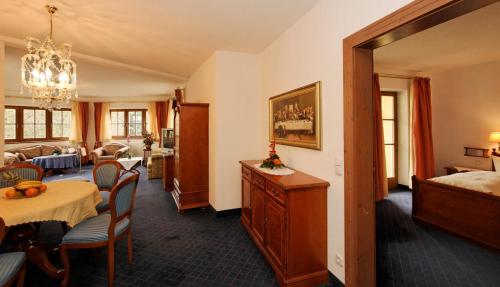 ein Hotelzimmer mit einem Bett, einem Tisch und Stühlen in der Unterkunft Wellnesshotel Parkschlössl zu Thyrnau " Adults only" in Thyrnau