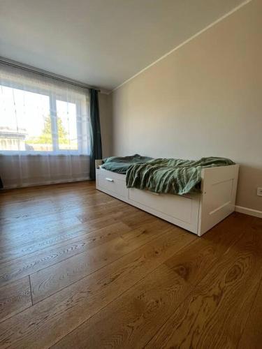 a bedroom with a bed and a large window at Ģimenes māja Jaunpilī in Jaunpils
