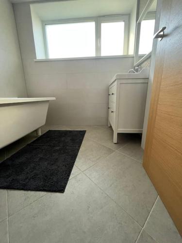 a bathroom with a tub and a sink and a mirror at Ģimenes māja Jaunpilī in Jaunpils