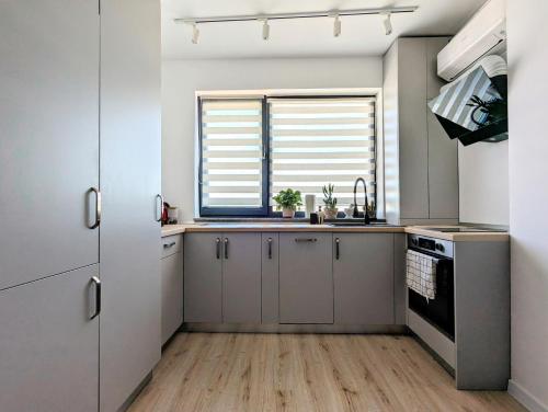 a kitchen with white cabinets and a window at Ivory Pipera in Voluntari
