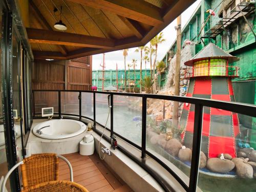 a balcony with a bath tub and a lighthouse at SKY PARADISE スカイパラダイス　ラクエン in Oita