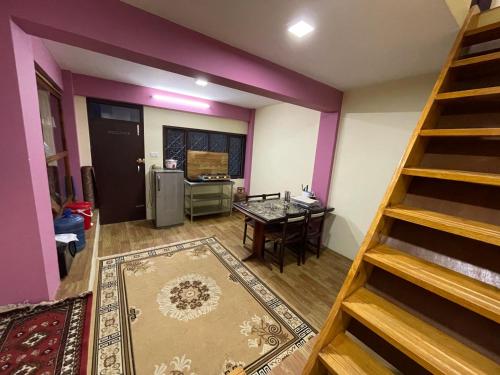 sala de estar con paredes de color púrpura y escalera en Kaji Homestay en Pātan