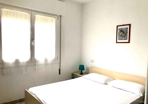 een witte slaapkamer met 2 bedden en een raam bij Apartment in Rosolina Mare 25005 in Rosolina Mare