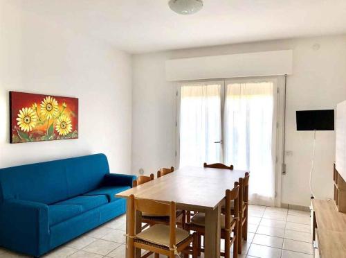 un soggiorno con divano blu e tavolo di Apartment in Rosolina Mare 25005 a Rosolina Mare