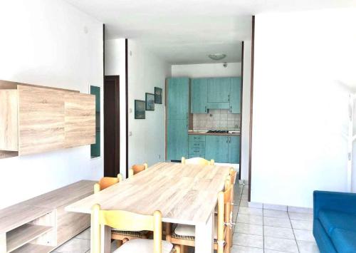 una sala da pranzo con tavolo in legno e armadi blu di Apartment in Rosolina Mare 25005 a Rosolina Mare