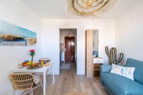 un salon avec un canapé bleu et une table dans l'établissement Surf & Yoga * Cosy * Vue sur le port * Proche Montpellier, à Carnon-Plage