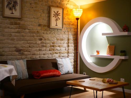 a living room with a couch and a brick wall at L'Escapade Inattendue in Calais