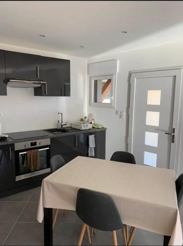 une cuisine avec une table et des chaises ainsi qu'une cuisine avec une cuisinière dans l'établissement Appartement Orelle/Val Thorens, à Orelle