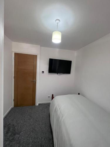 a bedroom with a bed and a flat screen tv at 7 Venus Road (Room 7) in London