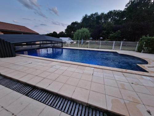une piscine dans une cour à côté d'une maison dans l'établissement Gte Mimosa - 6 people in the heart of the Dordogne, à Journiac