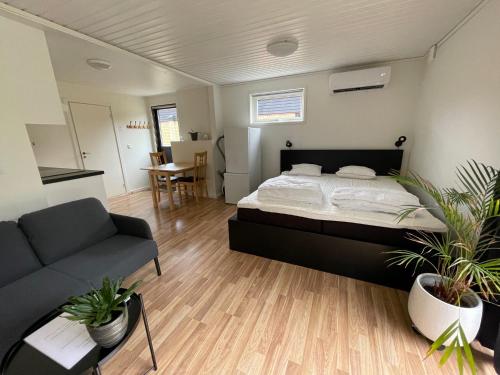 ein Schlafzimmer mit einem Bett, einem Sofa und einem Tisch in der Unterkunft Lilla Fajans in Falkenberg