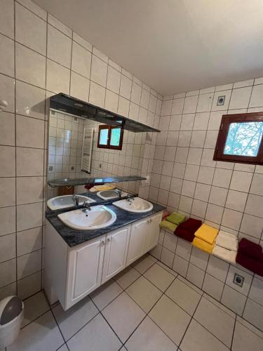 une salle de bain avec deux lavabos et un miroir dans l'établissement Gte Mimosa - 6 people in the heart of the Dordogne, à Journiac
