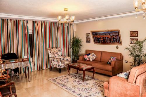 a living room with a couch and a chair at LOVELY PYRAMIDS motel in Cairo