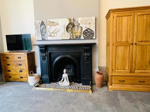 a room with a fireplace with a statue in front of it at Luxury garden apartment under the Castle, Dover in Dover