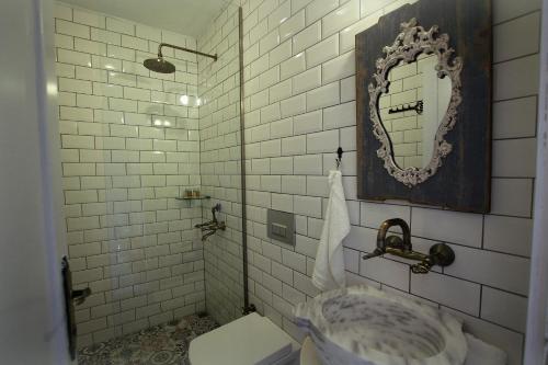 a bathroom with a sink and a mirror and a toilet at Assos 3 Oda private, luxury home in Behramkale