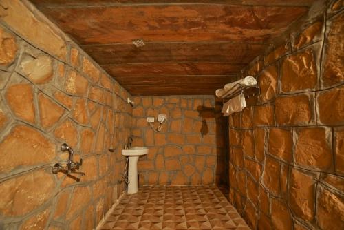 a bathroom with a toilet in a stone wall at Jaisalmer best desert Safari Camp in Jaisalmer