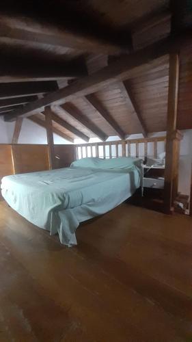 ein großes Bett in einem Zimmer mit Holzdecken in der Unterkunft Casa Arborea in Marrùbiu