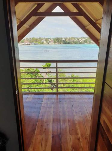 a view from the inside of a room with a view of the water at Wooden Guest House GASA in Dauis