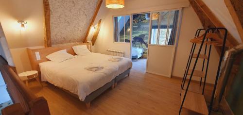 a small bedroom with a bed and a ladder at Le Domaine de la Férière in Sallen