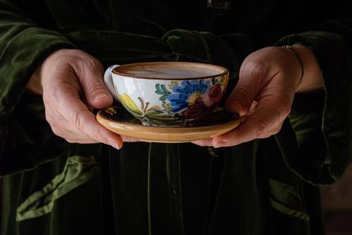 a person holding a coffee cup in their hands at Masseria D'Achille in Castel di Sangro