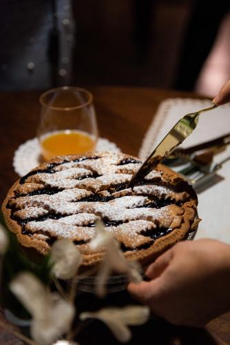 a person cutting into a cake with a knife at Masseria D'Achille in Castel di Sangro