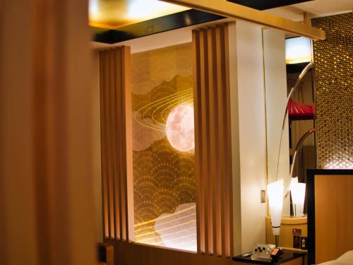 a window in a hotel room with a painting of the moon at SKY PARADISE スカイパラダイス　ラクエン in Oita